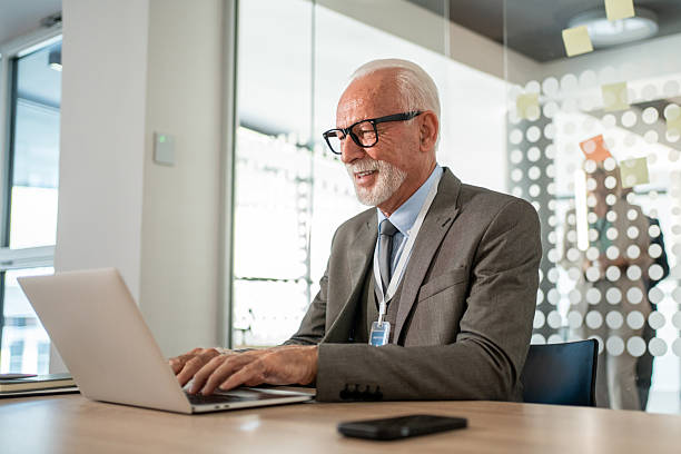 istock Senior businessman working on laptop in modern office 2225864533