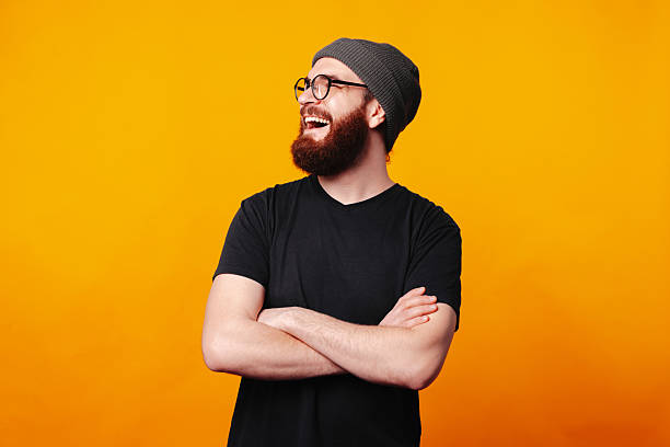 A Cheerful Bearded Man in Casual Attire Posing Against a Bright, Vibrant Background stock photo