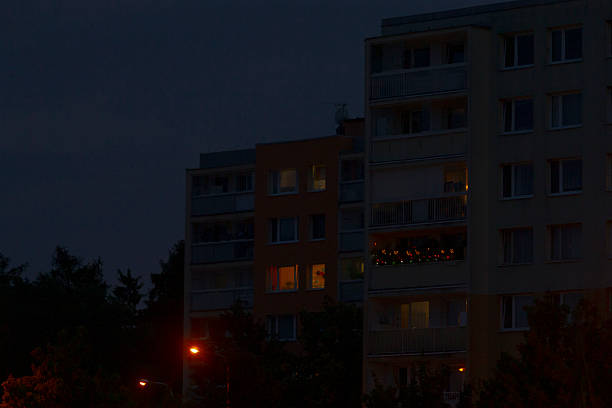 A large building adorned with numerous windows is beautifully illuminated during the night, creating a vibrant atmosphere in the city