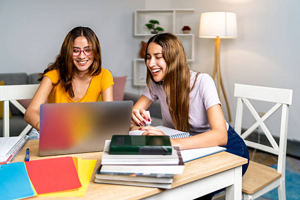 istock Two female college students doing homework together at home 2225880150