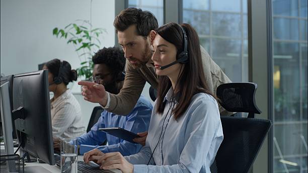 istock Multiethnic callcenter teamwork support service Caucasian man manager tablet pointing screen headset helpdesk woman employee African Indian coworkers call center office operators sale consult training 2225883866