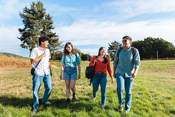istock Friends Laughing While Walking Together in a Park 2225887111