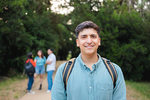 istock Latino college student outdoors with friends in background 2225888151