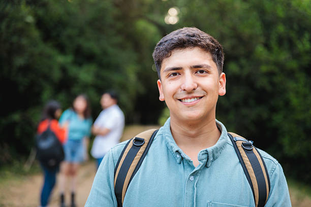 istock Latino student with backpack smiling in wooded campus setting 2225888152
