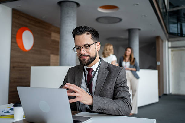 istock Businessman working on laptop in modern office with colleagues 2225889207