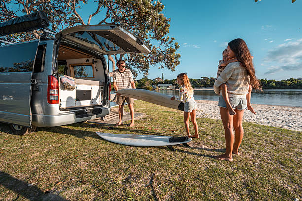 istock Happy Family Unloading Surfboards from Van at Camping Spot 2225890569