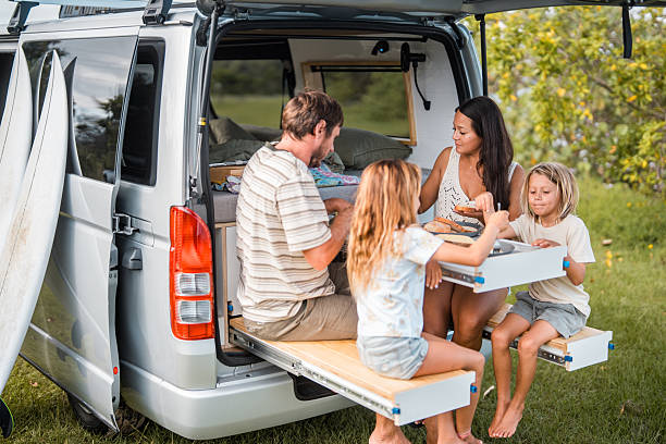 Family Enjoying Outdoor Breakfast by Campervan in Bright Morning Light