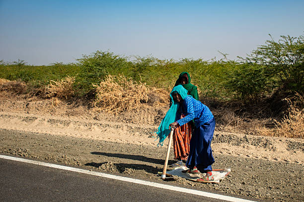 January, 23rd, 2025, Bhuj, India: Unskilled Indian laborers working on a road construction site under the blazing summer sun, capturing the harsh reality and resilience of rural daily wage earners in India.
