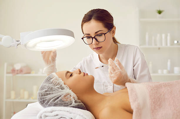 istock Beautician makes injection to smooth out wrinkles between eyebrows on woman's face. 2225900298
