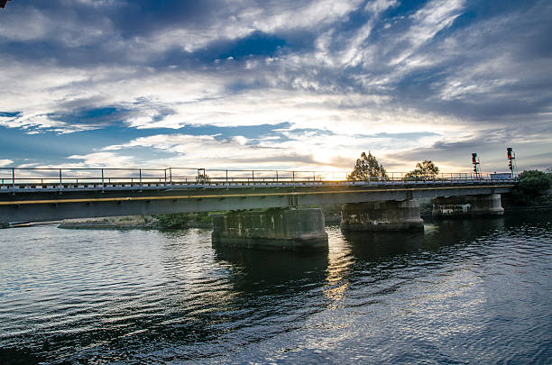 istock Beautiful Sunset clouds sky above Structural steel bridge crossing the river 2225901393
