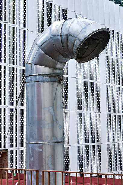 Three metal smoke stack on the top of a building