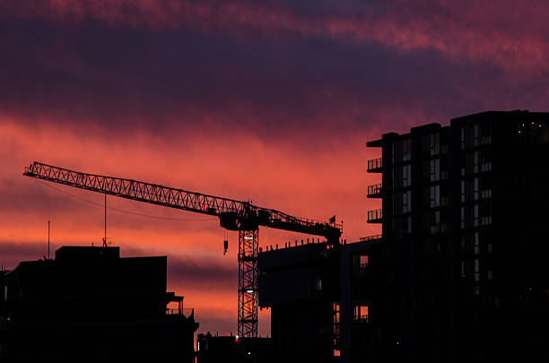 Silhouette of construction cranes at sunset