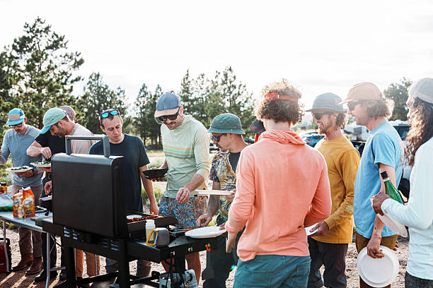 A large group of male friends on a bachelor party trip in Wyoming make tacos for dinner at their campsite after a bouldering session at Vedauwoo Recreation Area.