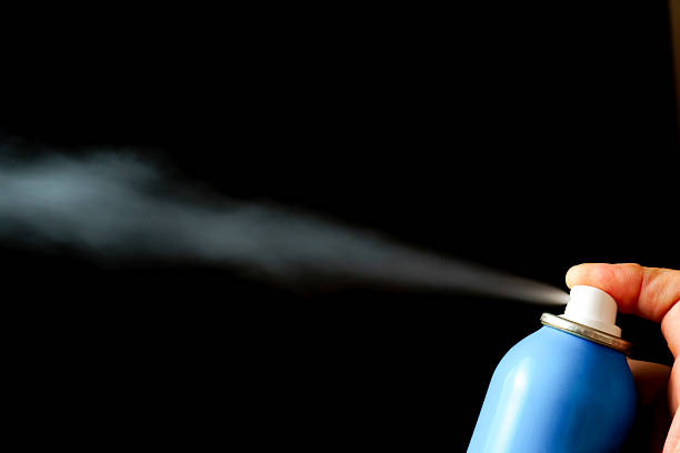 istock Finger pressing a blue spray can emitting vapor on black background 2225910810