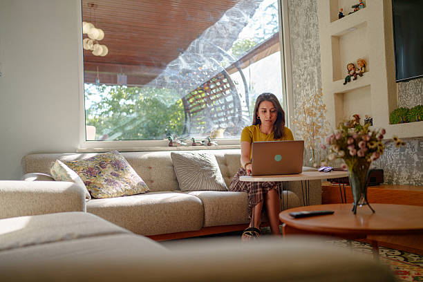 istock Young Woman Using Laptop on Sofa in Living Room 2225912146
