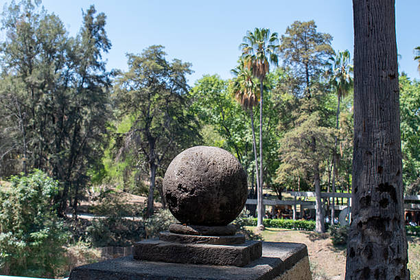 Stone sphere on pedestal overlooking forest and palm trees in Colomos Forest