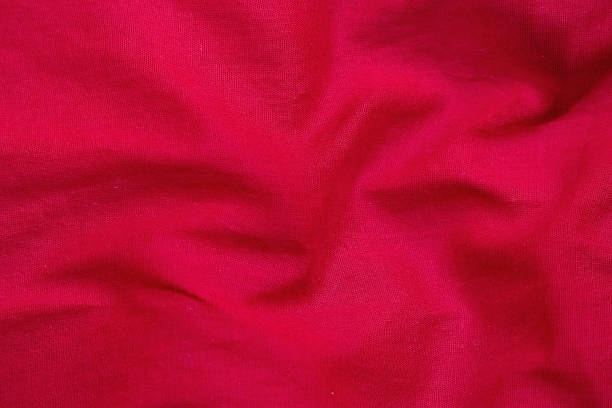 istock Soft red cotton fabric texture background. Wavy, draped cloth with natural textile patterns. Perfect for fashion, crafts, and abstract design elements. 2225935307