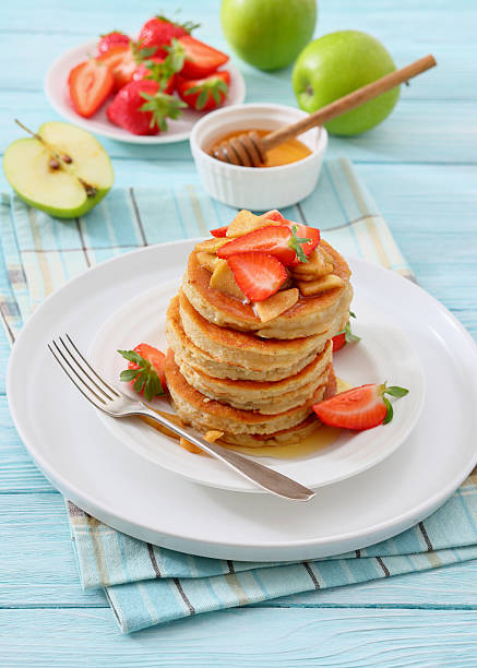 istock pancakes topped with apple slices and strawberries 2225939943