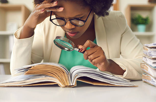 istock Closeup concentrated african american auditor scrutinizing financial documents 2225942371
