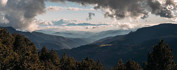 istock Dramatic layered mountain landscape under thick cloud cover with sunlight breaking through 2225945090