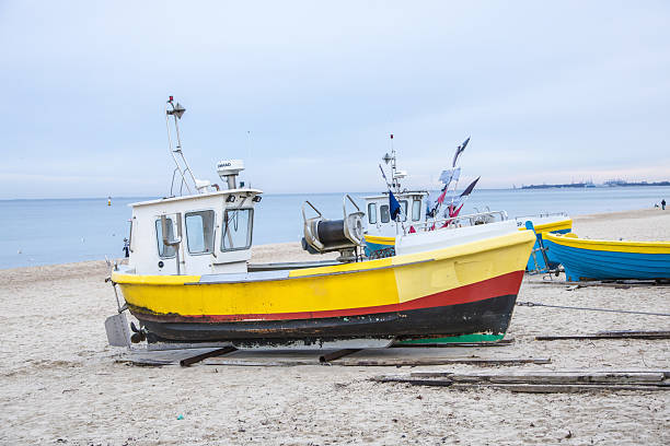 istock A small yellow fishing boat on a sandy beach 2225945416