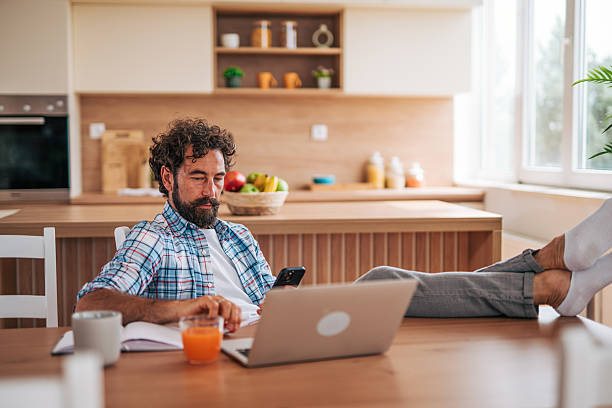 istock Freelancer working from home in modern kitchen with feet up 2225945688