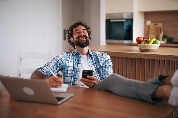 Young man working from home and relaxing with feet up on the table