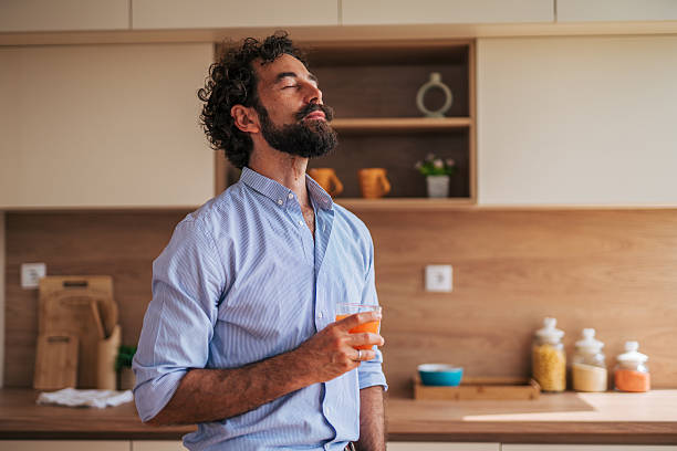 istock Relaxed man enjoying a refreshing drink in modern kitchen 2225945907