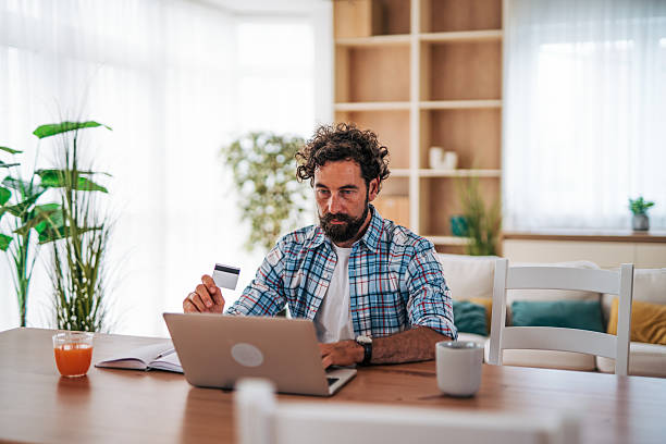 istock Focused man making online payment with credit card at home 2225946531