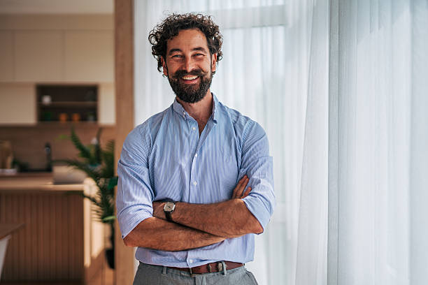 istock Confident businessman smiling with arms crossed in modern office 2225946865