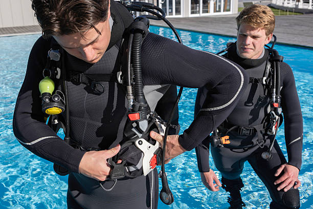 istock A scuba diver is getting his gear ready by inserting a weight pocket 2225947234