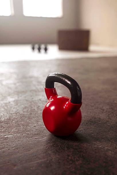 Red Kettlebell on Gym Floor in Sunlight
