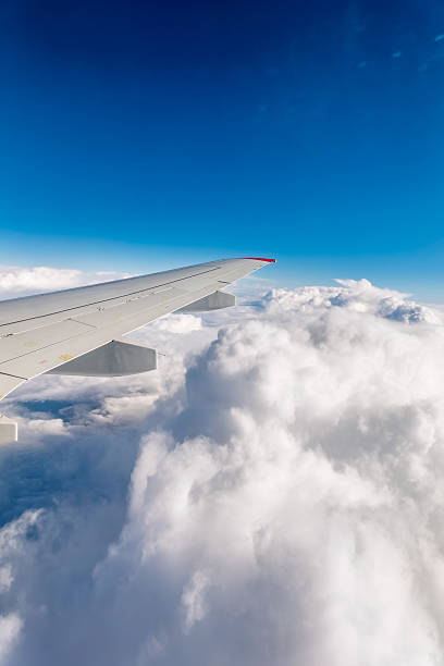 istock View from the airplane window at a beautiful cloudy sky and the airplane wing 2225951468