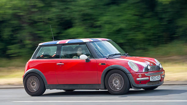 Toronto, Ontario, Canada- July 1, 2023. Chili red colour MINI COOPER on the urban street  in downtown Toronto East side, Canada. Evening in spring time. This is the third generation model F56 JCW, since BMW took over iconic brand of MINI. MINI featured in the photo is John Cooper Works model, the most powerful 2 door version. This compact car features engine build and designed by BMW, and packs even more power and torque than previous models, since 2002 to present. Original design clues and themes are still present on this brand new model. Mini has been around since 1959 and has been owned and issued by various car manufacturers.