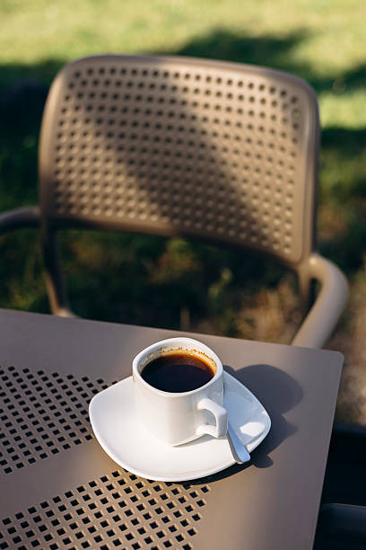 istock Cup of black coffee on table outdoors in garden or terrace setting. 2225960526