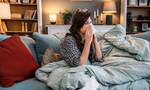istock Sick woman with cold lying under blanket at home 2225966113