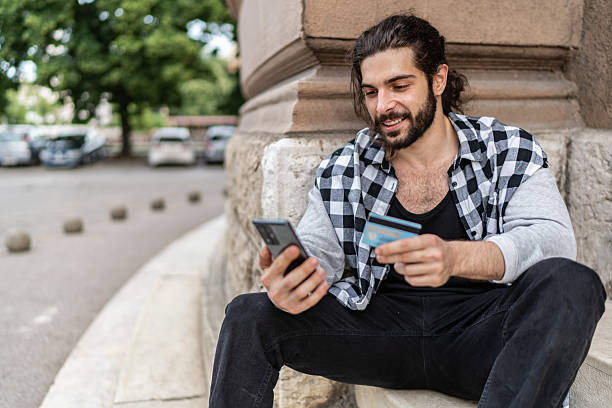 istock Young man making online payment using smartphone and credit card 2225966349