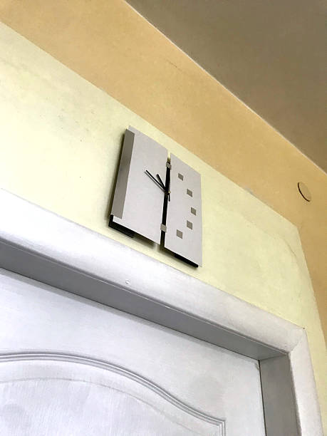 Unique modern wall clock design above a white door