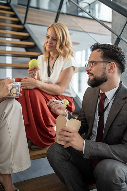 istock Business people eating lunch on office stairs during break 2225975195