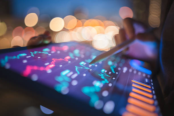 istock Hand using a stylus on a tablet displaying glowing digital financial charts and intricate data against a soft-focus background, illustrating modern financial technology. 2225980317