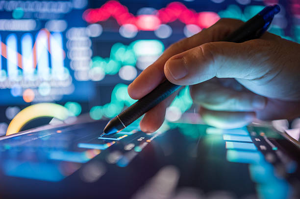 istock Hand interacting with a digital tablet displaying financial data charts and graphs in a vibrant, futuristic interface, symbolizing AI-driven market analysis or fintech innovation. 2225980318
