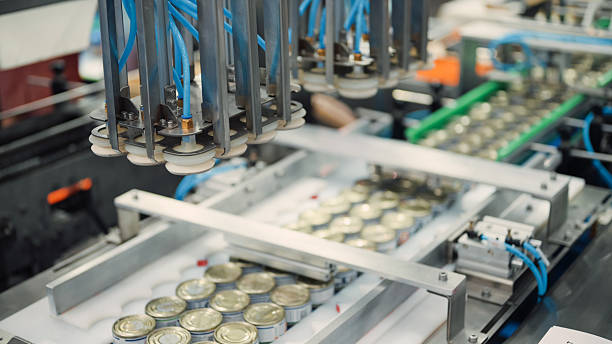 istock Automated canning or filling machine processing multiple small metal cans on a production line. 2225980422