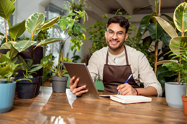 istock Flower shop assistant analyzing online orders and looking contented 2225985879