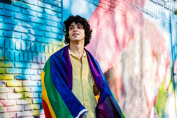 istock Young man with rainbow flag looking away outdoors 2225986515