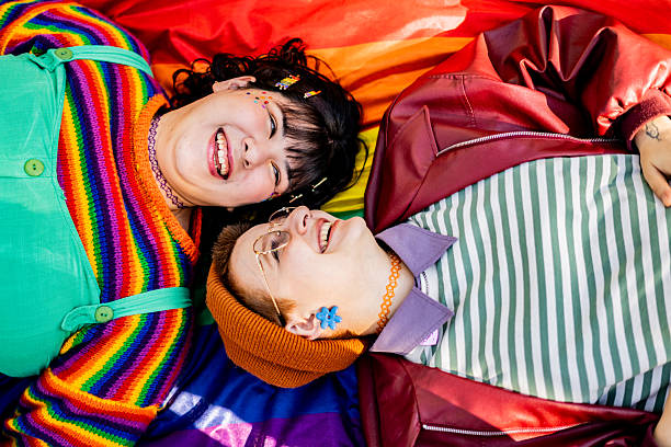 istock Gay couple talking lying down on grass at public park 2225986716