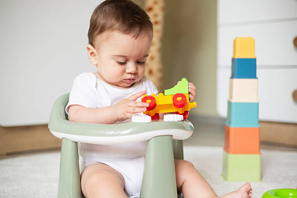 istock Baby playing with toy blocks sitting at home 2225987710