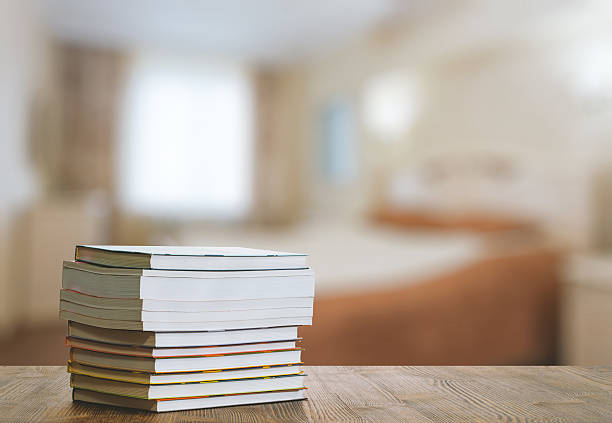 Pile on books with reading glasses on bedside table