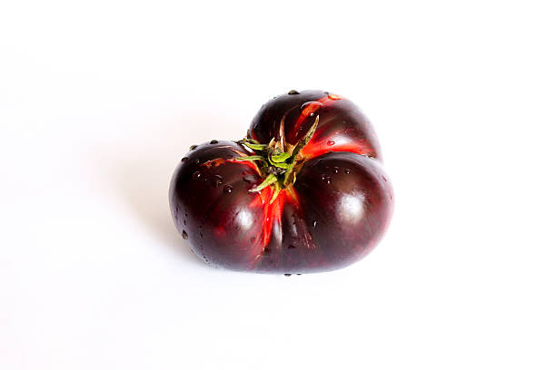 Fresh ripe black tomatoes isolated on white background. Krim or Kumato tomato.