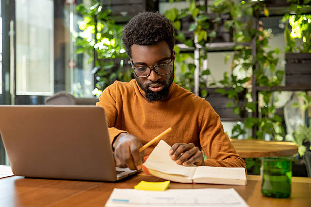 istock Man in glasses working on laptop reviewing digital reports 2225991281