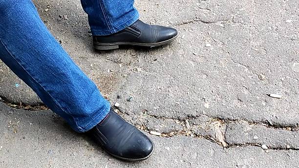 istock A man sitting down, nervously beating out a rhythm on the pavement with his foot, showing impatience and anticipation 2225992192